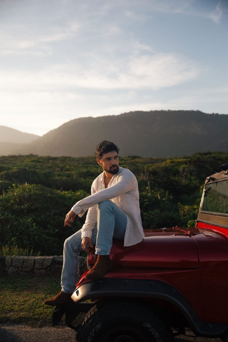 Cantor Brunno Daltro em um carro ao por do sol em sua nova estética de clipe