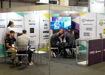 Estande da PagSeguro na área B2B da Brasil Game Show 2025, com grupos de profissionais conversando em mesas sobre soluções de pagamento e parcerias estratégicas.
